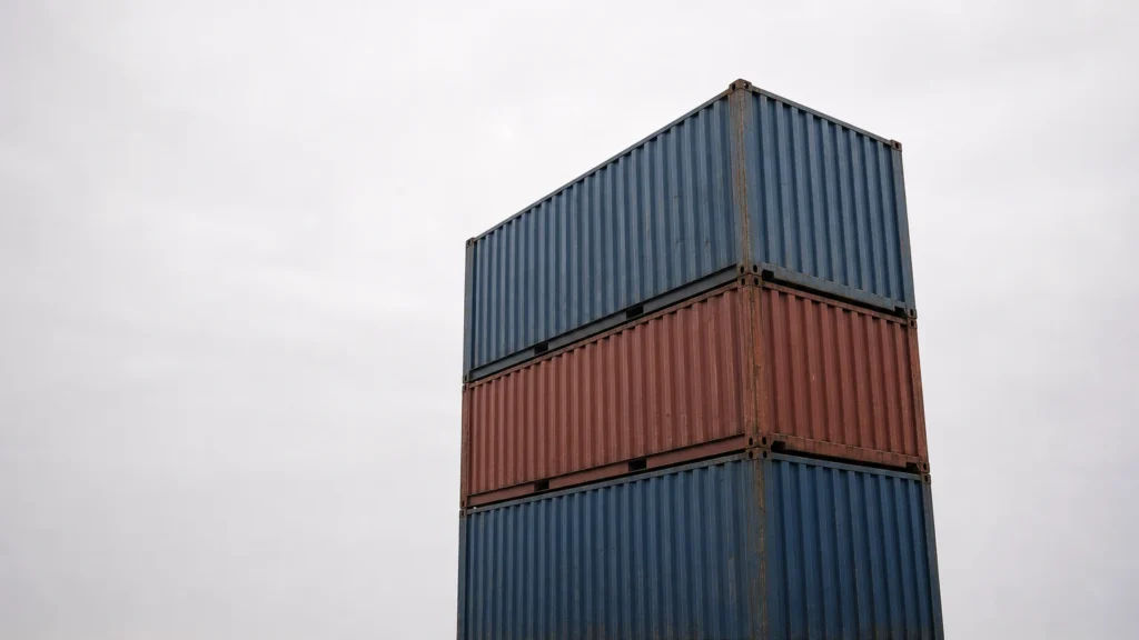 Chồng ba container vận chuyển được chụp từ góc thấp trên nền bầu trời nhiều mây rộng lớn